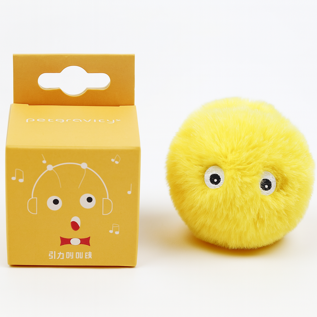 Yellow plush toy with googly eyes next to its packaging on a white background